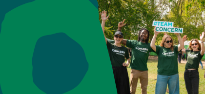 A group of Concern Worldwide supporters wearing green T-shirts smile and wave at an outdoor event. One person holds a "#TEAM CONCERN" sign above the group, celebrating their fundraising efforts, while a green branded graphic panel fills the left side of the image.