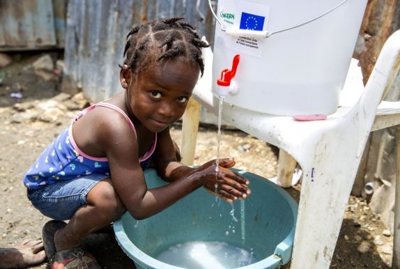 Cherica (2) washes her hands in front of her grandmother's home in Cite Soleil, a district of Port-au-Prince, Haiti. Photo: Dieu Nalio Chery/ Concern Worldwide