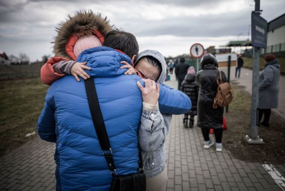 A man hugs his daughter and granddaughter after they crossed the border from Shehyni in Ukraine to Medyka in Poland. Numerous Ukrainians are leaving the country fleeing the conflict. Photo: Michael Kappeler/dpa