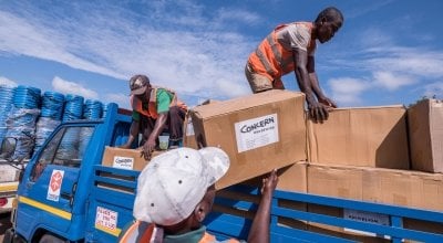 Workers unload kitchen kits from a truck at a distribution in Ndeja, Mozambique, which was hard hit by cyclone Idai in March 2019. Photo: Tommy Trenchard / Concern Worldwide