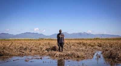 Recently married Patrick Ghembo of Monyo Village, Malawi, standing in his field, destroyed by the floods. Patrick is a farmer of maize and rice. He and his wife must rely solely on fishing until he can plant again. They will stay at the displacement camp until the floods have fully subsided. Photo: Gavin Douglas