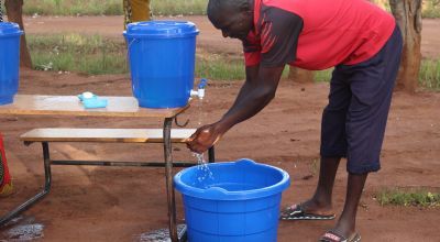 Enika Mussa  practices good hand washing to prevent the spread of Covid-19. He is attending the Concern Consumption (Cash) Support Distribution through he Graduation Programme in Mangochi District, Malawai. Photo: Levy Mwambarulu Kadrab / Concern Worldwide