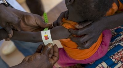 A health worker at a Concern-supported clinic at Gbadengue carries out a regular health assessment of 17-month-old Nicoles. She was diagnosed as severely malnourished two weeks ago. Since then, she has put on more than half a kilo. Photographer: Chris de Bode