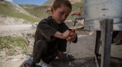 Child uses handwashing station in Afghanistan