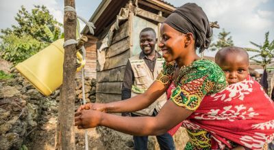 Apoline Niyosenge is taught how to wash her hands properly by Concern community worker Abel Bamwisho, DRC. Photo: Pamela Tulizo