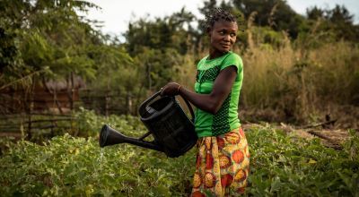 Irene waters the aubergines in her community’s vegetable garden in Pension, Manono Territory. Photo: Hugh Kinsella Cunningham/Concern Worldwide
