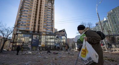 A woman walks past a damaged building on a street after curfew temporarily lifted amid attacks in Kyiv, Ukraine on February 28, 2022. (Photo by Aytac Unal/Anadolu Agency via Getty Images)