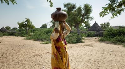 A woman walks home after collecting water from a solar-powered water pump made by Concern in Pakistan. Photo: Khaula Jamil/Concern Worldwide