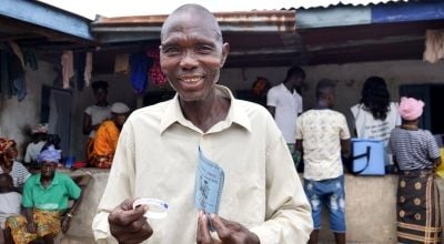 Victor S Canteh (46) holds his vaccination card after receiving his second vaccination in Madif. 'I am very glad I was able to get my second dose.’ Photo: Conor O'Donovan / Concern Worldwide.