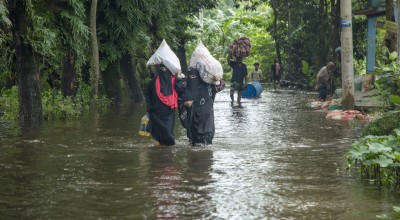 Women walk through flooded streets