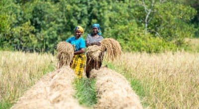 Two women in a filed holding their harvest