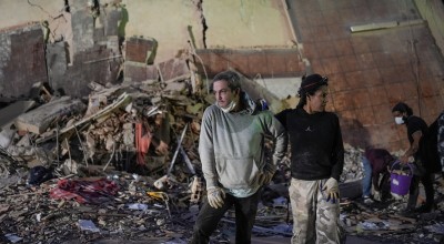 People stand at the site of a collapsed building following an earthquake in Caracas on June 25, 2026