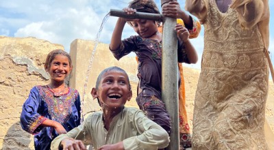 Children are bathing in the water of a village hand pump to cool down during the heatwave. Photo: Arif Shad/Concern Worldwide.