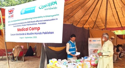 An aid worker provide essential supplies to a man in Pakistan