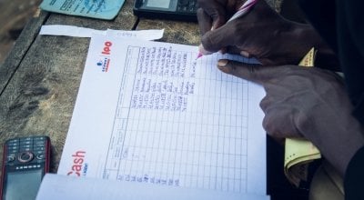 Nijimbere Alphonsine, NGO Concern staff member giving out cash transfers. Photo: Irenee Nduwayezu / Concern Worldwide. 