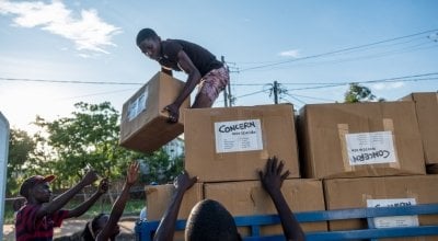 Esparanza Maria, a 25-year-old day worker from Nhamatanda, helps load boxes containing essential household supplies from a warehouse to a truck. The items will be distributed the next day in the village of Ndeja. "It makes me feel good to be able to help 