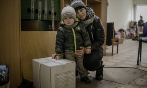 Darina* and her young son, Petro* with their food kit. Photo: Simona Supino/Concern Worldwide