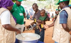 A man brings his son to a distribution of food