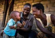 Eric Kyugu and Mado Kabulo, a married couple play with their 7-month-old baby Bienheureux in the village of Pension, Manono Territory.