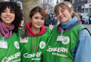 Three smiling street fundraisers wearing green Concern vests