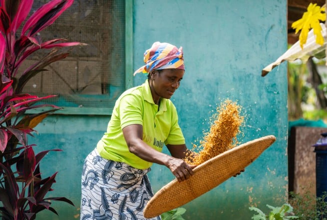 A woman tossing grains into the air