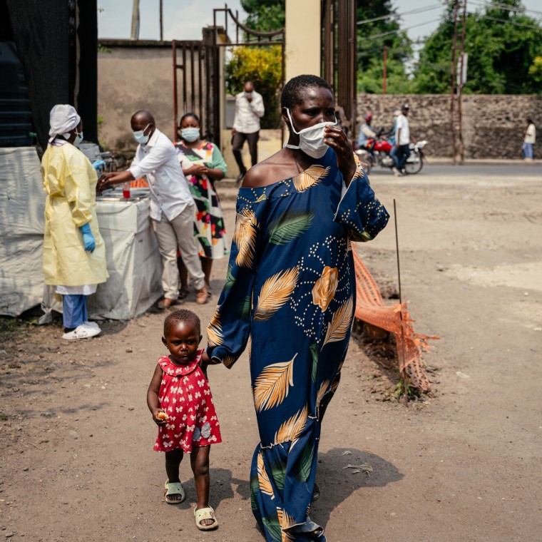 A woman wearing a mask as a preventive measure enters Kyeshero Hospital after passing a checkpoint for hand washing and health screening in Goma