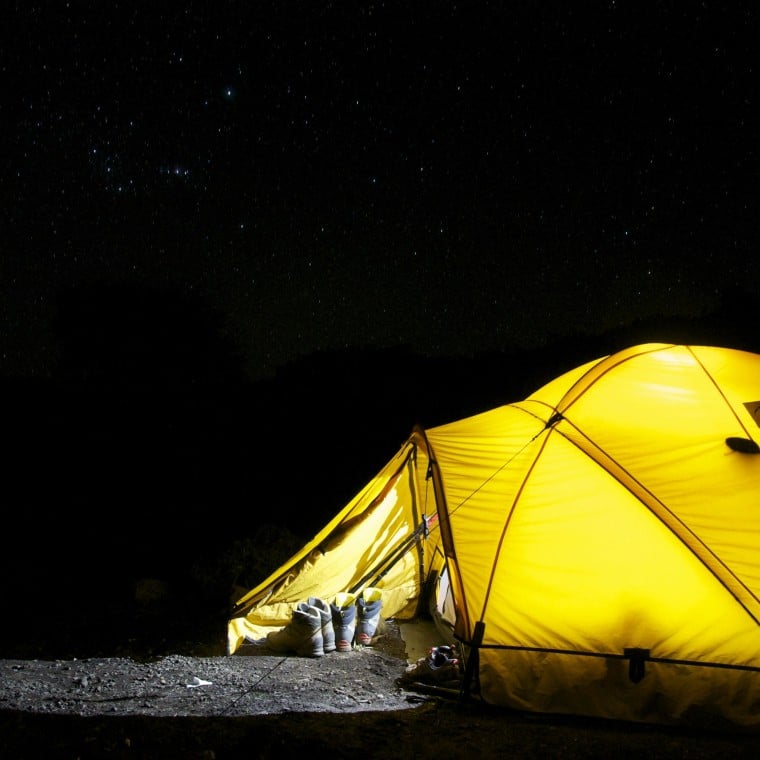 A yellow tent lit up at night